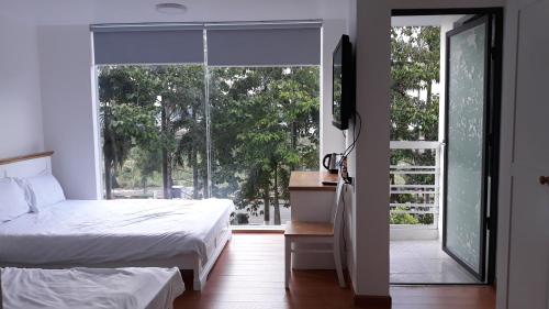 a bedroom with a bed and a large window at Hana Riverside Villa in Quảng Ngãi