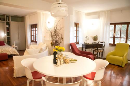 un soggiorno con tavolo e sedie bianchi di L'angolo sul Parco - Suite a Matera