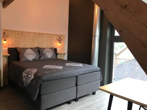 a bedroom with a bed with a large window at De Hostee in Stolwijk
