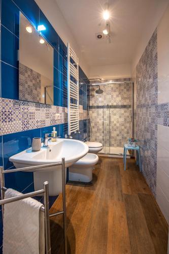 a bathroom with a sink and two toilets and blue walls at B&B PETER PAN in Salerno