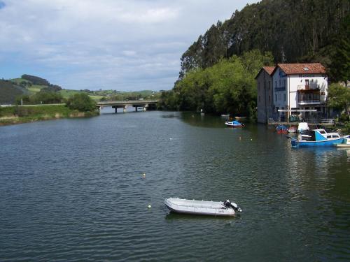a small boat in the water next to a building at Posada de Muño in Muñorrodero