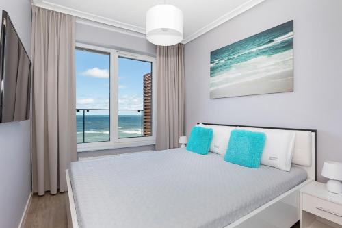 sypialnia z łóżkiem i widokiem na ocean w obiekcie Apartos Sailor - Luxury Apartments w mieście Ustronie Morskie