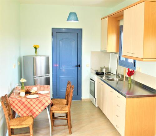 cocina con mesa y puerta azul en Stamna Farm, en Romanós