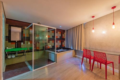 a room with two red chairs and a pool table at Spa urbano Motel Adult Only in Fortaleza