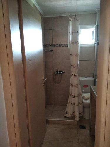 a bathroom with a shower with a shower curtain at LOUKIA'S HOUSE in Skala Kallirakhis