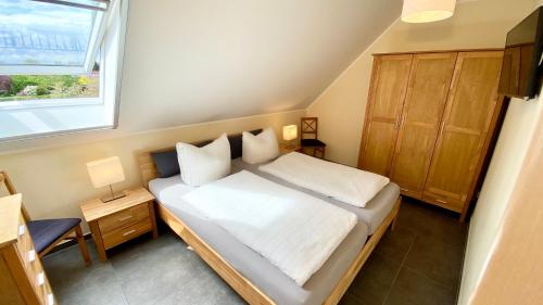 ein kleines Schlafzimmer mit einem Bett und einem Fenster in der Unterkunft Spreewäldchen in Lübben
