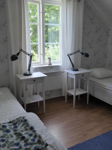 two lamps on two tables in a bedroom with a window at Villa Freja in Linköping