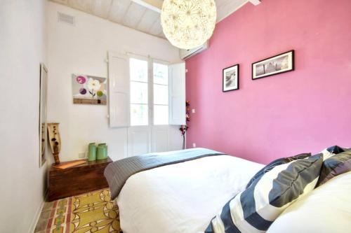 ein Schlafzimmer mit einer rosa Wand und einem Bett in der Unterkunft Valletta Maison d'art - Centre APT in Valletta