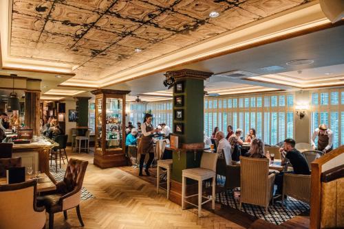 a group of people sitting at tables in a restaurant at Busby Hotel in Busby