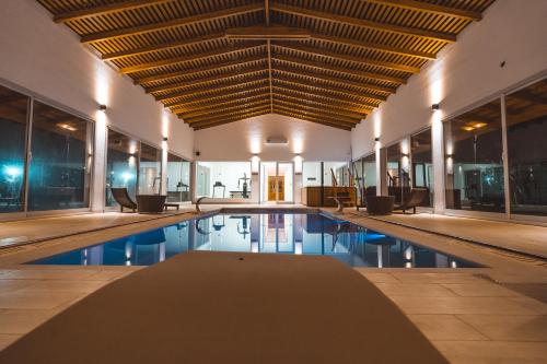 an indoor swimming pool with chairs and a ceiling at Nono Luigi in Oncativo