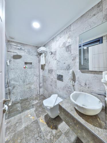a bathroom with a sink and a toilet and a mirror at Villa Kas Bohem in Kaş