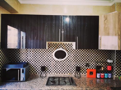 eine Küche mit einer schwarz-weiß karierten Wand in der Unterkunft H3 in Agadir