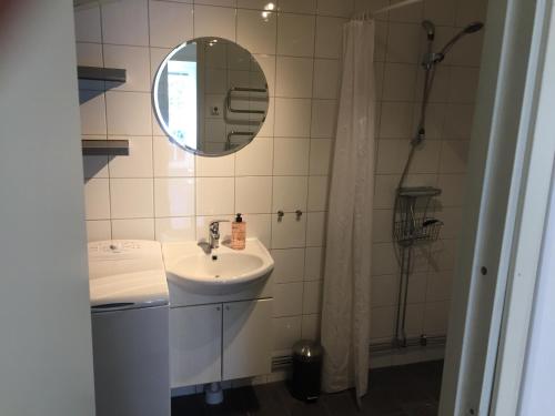 a bathroom with a sink and a mirror at stuga skrea strand in Falkenberg
