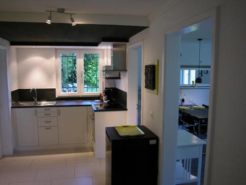 a kitchen with white cabinets and a black counter top at Joline private guest apartment just feel at home 