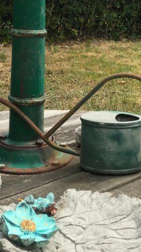 a green pole with a flower next to a pot at Lyckhus in Ljungskile