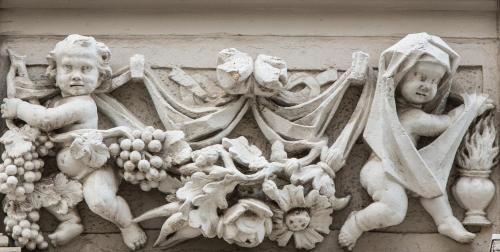 a statue of two cherubs and fruit on a wall at Hotel Fregehaus in Leipzig