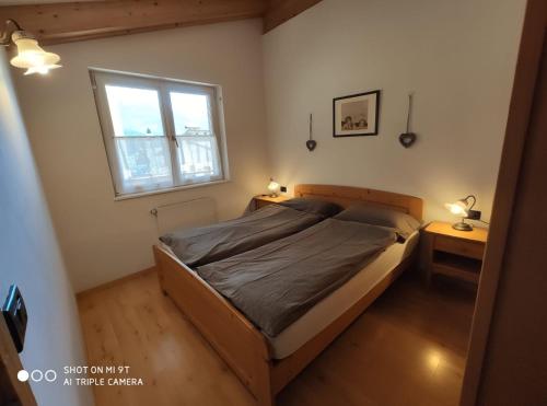 a bedroom with a bed and a window at Residence Montebel in Tesero