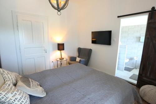 a bedroom with a bed and a chair and a television at Vánkos in Badacsonyörs