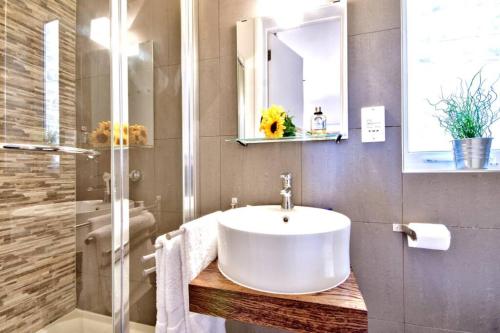 een badkamer met een witte wastafel en een douche bij Valletta Art PentHouse with seaview in Valletta