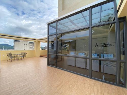a large glass building with a table and chairs at Owl Hostel 貓頭鷹旅店 in Yuchi