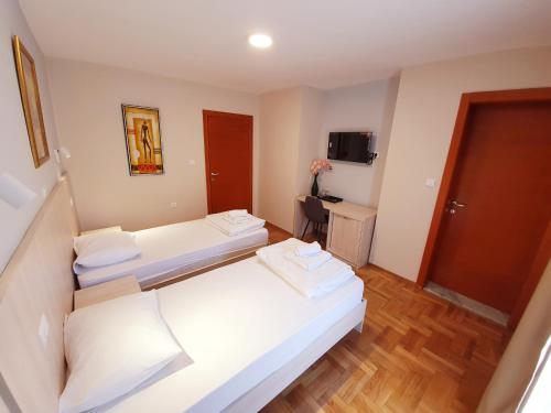 a hotel room with two beds and a television at Apartments Pier in Budva