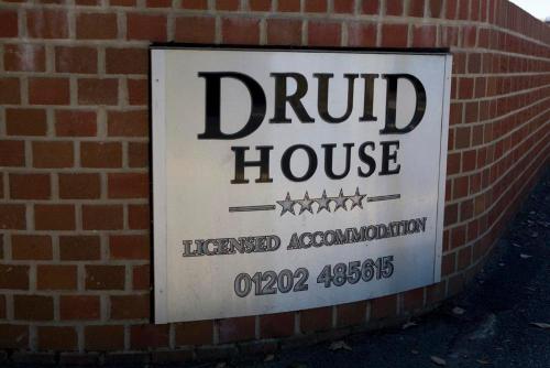 a sign for a drug house on a brick wall at Druid House in Christchurch