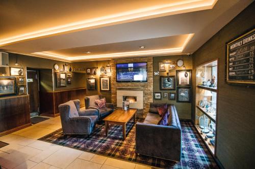 a living room with two couches and a television at The Torrance Hotel in East Kilbride