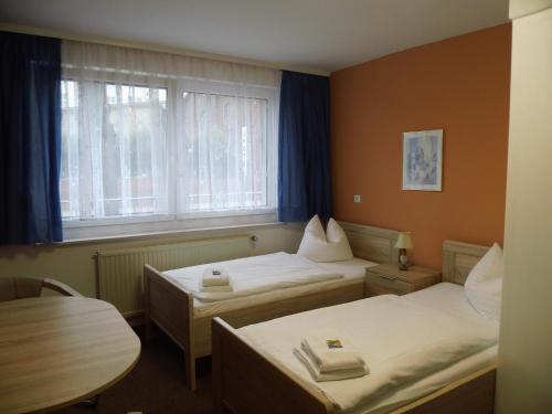 a hotel room with two beds and a window at Hotel Sturm in Tangermünde