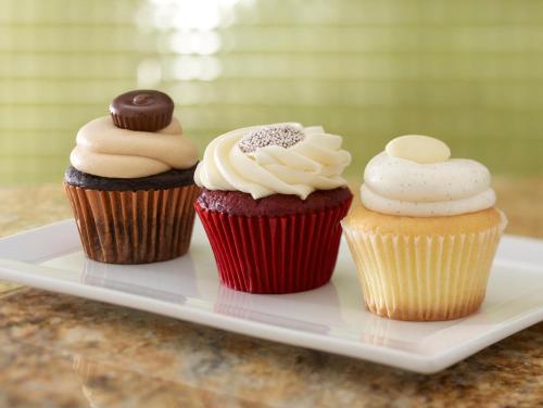 three cupcakes on a plate on a table at Hyatt Place Calgary Airport in Calgary