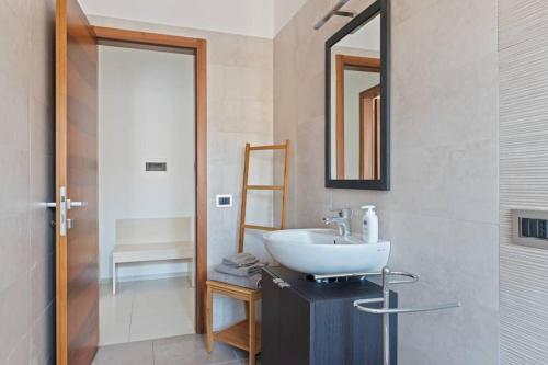 ein Bad mit einem Waschbecken und einem Spiegel in der Unterkunft Modern and new apartment in Brianza in Vimercate