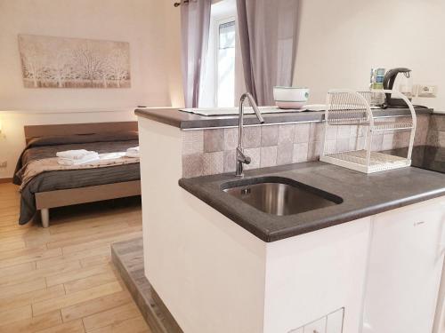 uma cozinha com um lavatório e um quarto com uma cama em Residence Serra La Nave em Ragalna