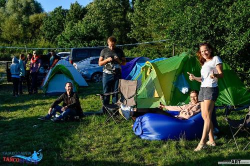 Kajakodajnia Campsite at the Wierzyca river في Kolińcz: مجموعة من الناس في حقل مع الخيام