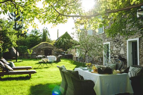 a garden with a table and chairs in the grass at Vánkos in Badacsonyörs