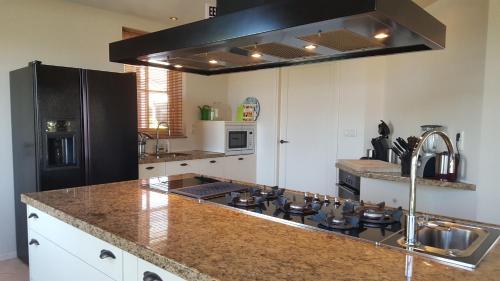 a kitchen with a stove and a counter top at Villa Pura Vida in Oud-Ade