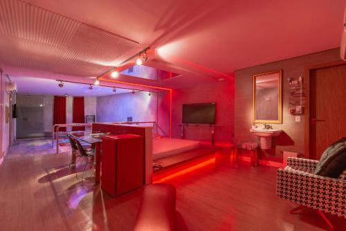 a living room with red lighting and a bed in a room at Spa urbano Motel Adult Only in Fortaleza