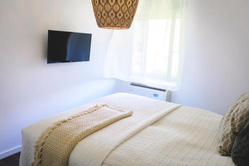 a bedroom with a bed with a tv on the wall at Vánkos in Badacsonyörs