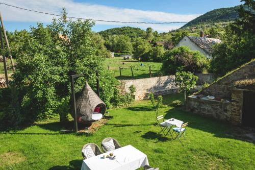 a garden with a table and chairs in the grass at Vánkos in Badacsonyörs