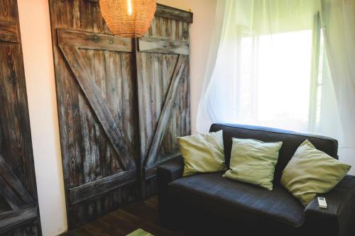 a black couch with two pillows in front of a door at Vánkos in Badacsonyörs