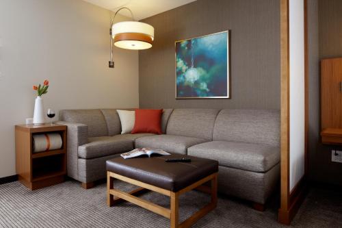 a living room with a couch and a table at Hyatt Place Calgary Airport in Calgary
