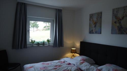 a bedroom with a bed and a window at Europa-Feriendorf Husen in Husen