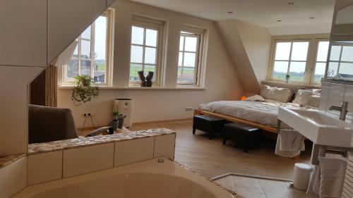a bathroom with a bed and a tub in a room at Villa Pura Vida in Oud-Ade