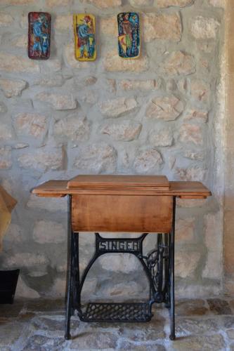 a wooden table in front of a stone wall at Oasi di Campagna in Modica