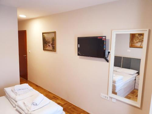 um quarto com um espelho e uma televisão na parede em Apartments Pier em Budva