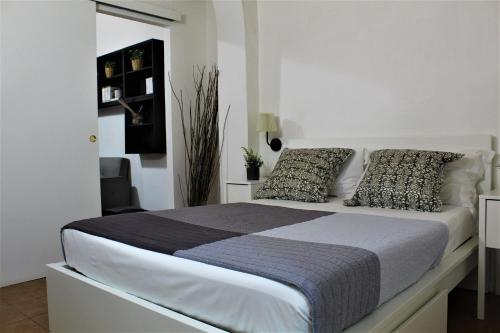 a white bedroom with a large bed with pillows at Crystal Ship Apartments in Florence