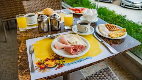 a table with breakfast foods and drinks on it at Hotel Beira Mar in Fortaleza