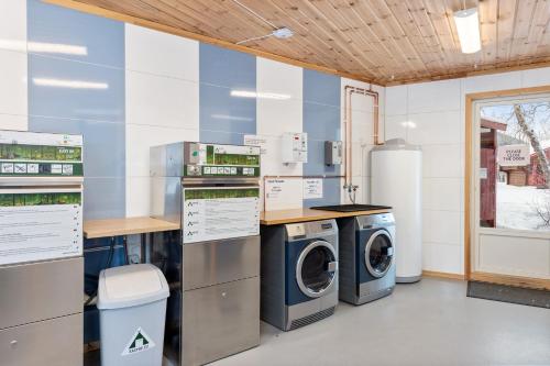 a laundry room with washing machines and a window at Birkelund camping in Hovet