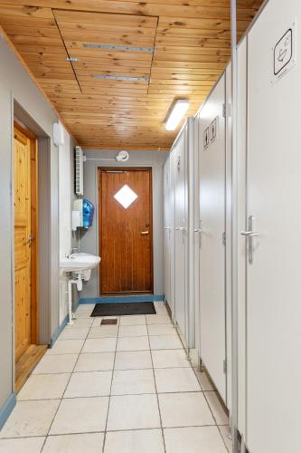 a hallway with a wooden door and a sink at Birkelund camping in Geilo
