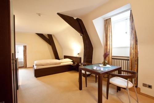 Zimmer mit einem Tisch und einem Bett sowie einem Tisch und Stühlen in der Unterkunft Schloss Raesfeld in Raesfeld