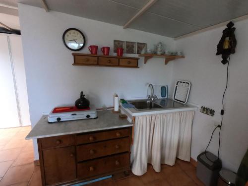 - une cuisine avec un comptoir, un évier et une horloge dans l'établissement FREEDOM, à Tablado de la Montañeta