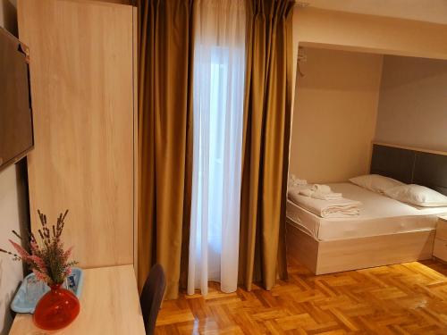 a small room with a bed and a window at Apartments Pier in Budva